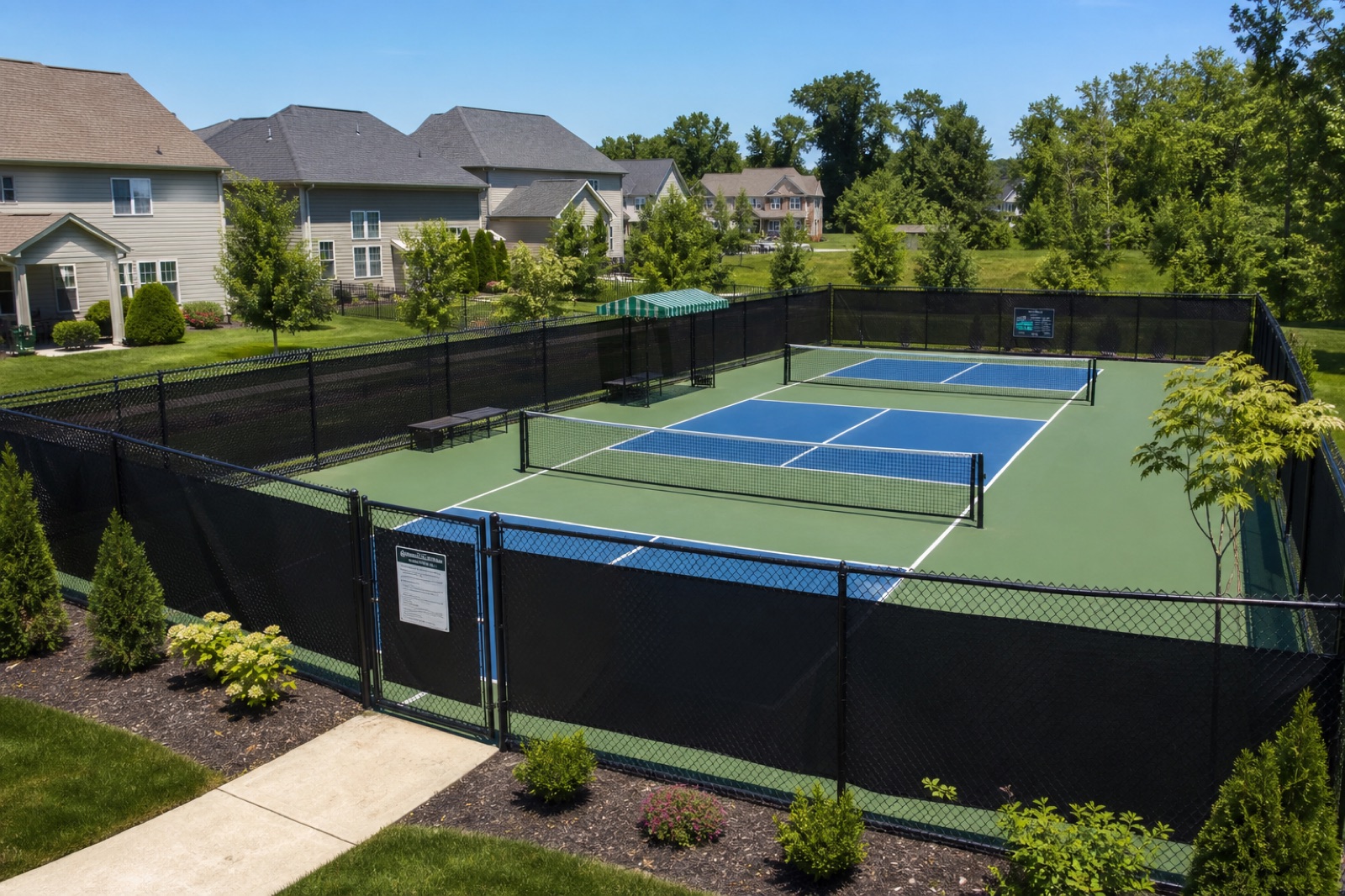 Two blue and green pickleball courts in a residential community