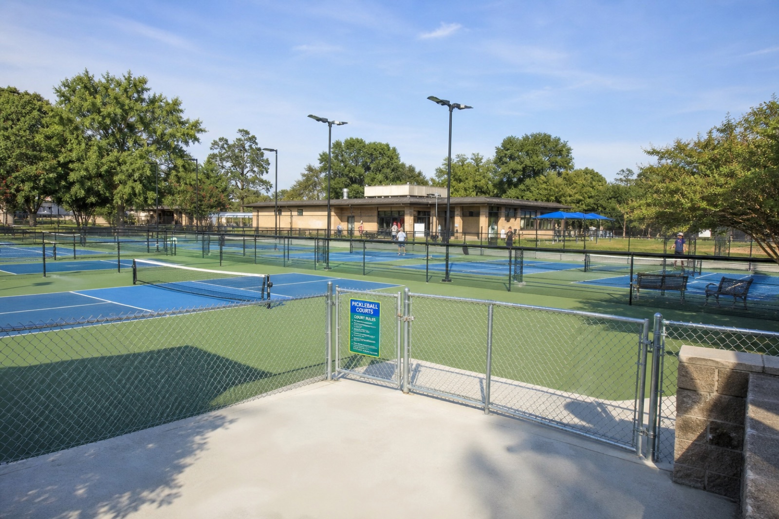 Multi-court public pickleball facility with accessible gates, lighting, and seating