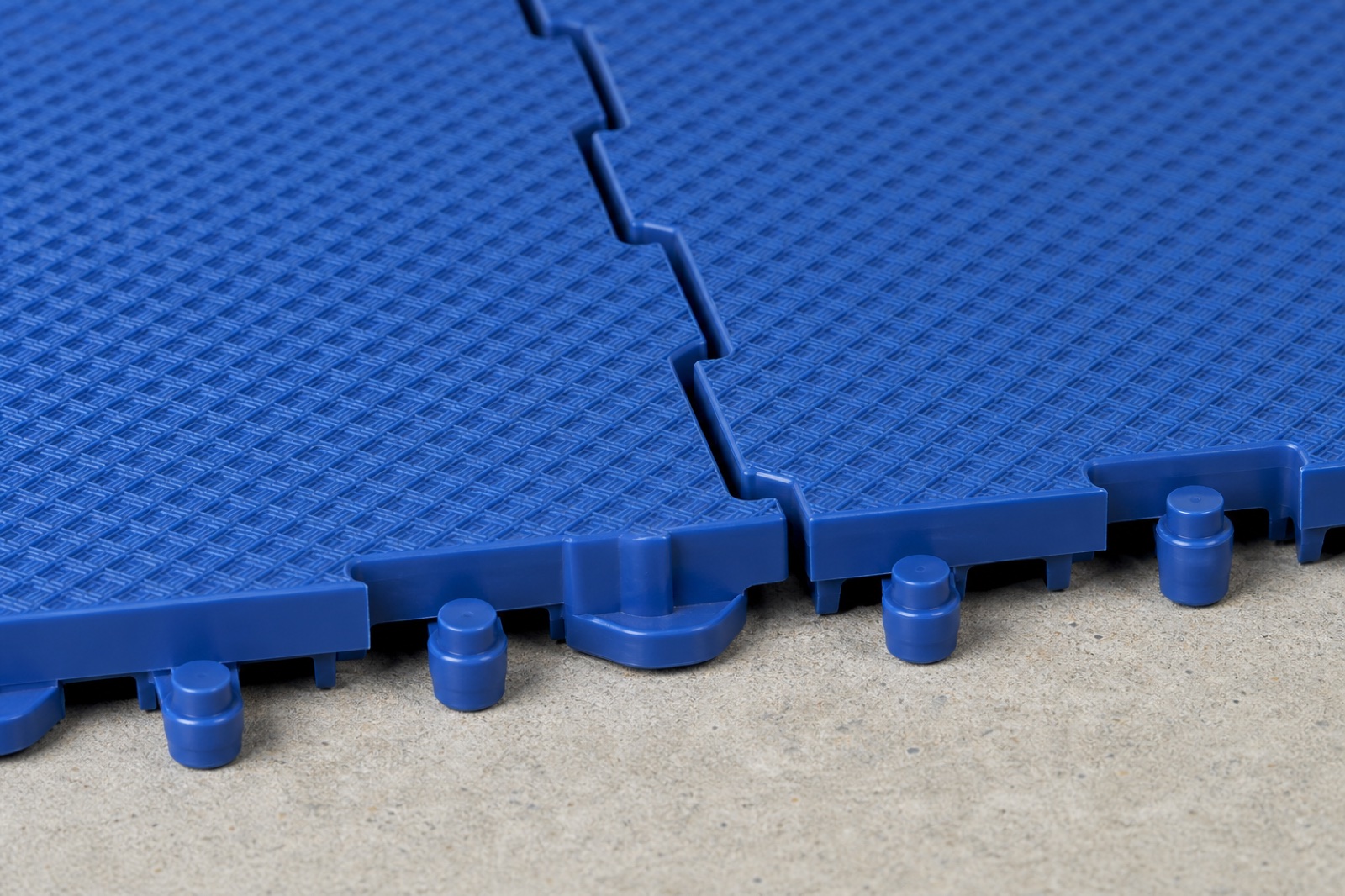 Close view of blue modular sport tiles and their interlocking edge