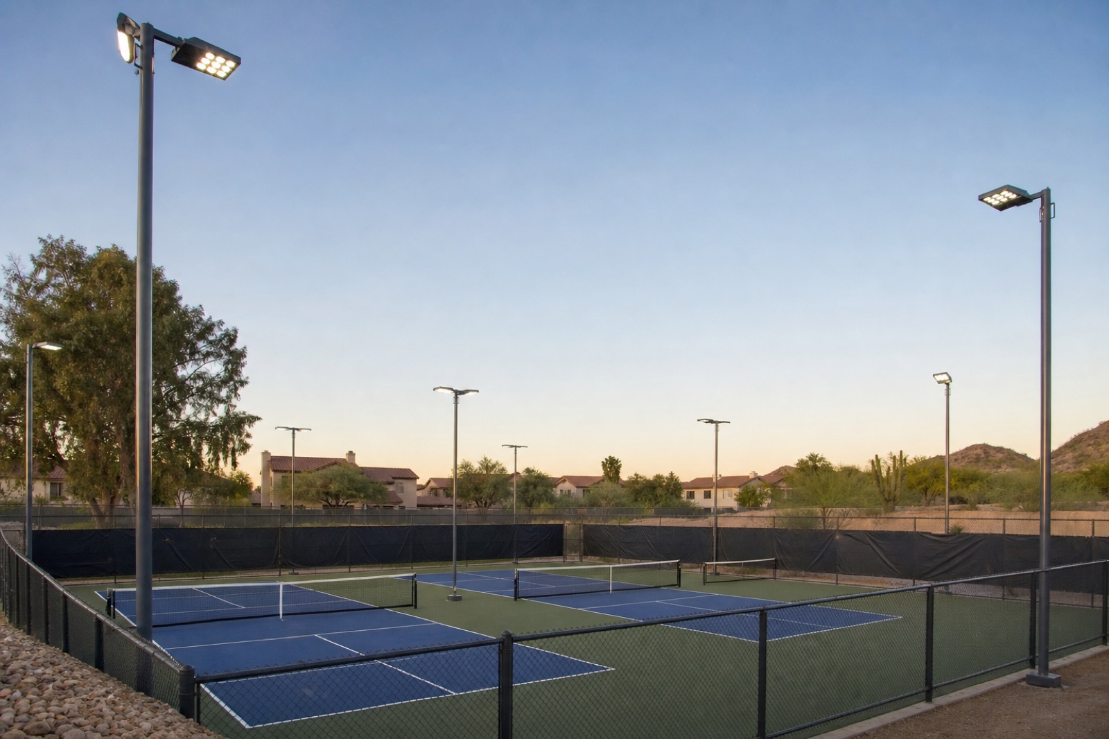 Court light poles and LED fixtures positioned around a pickleball court