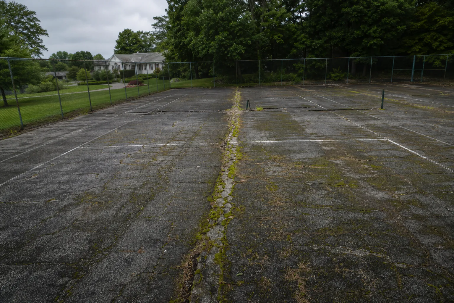 Deteriorated tennis courts before the Bluegrass Country Club conversion