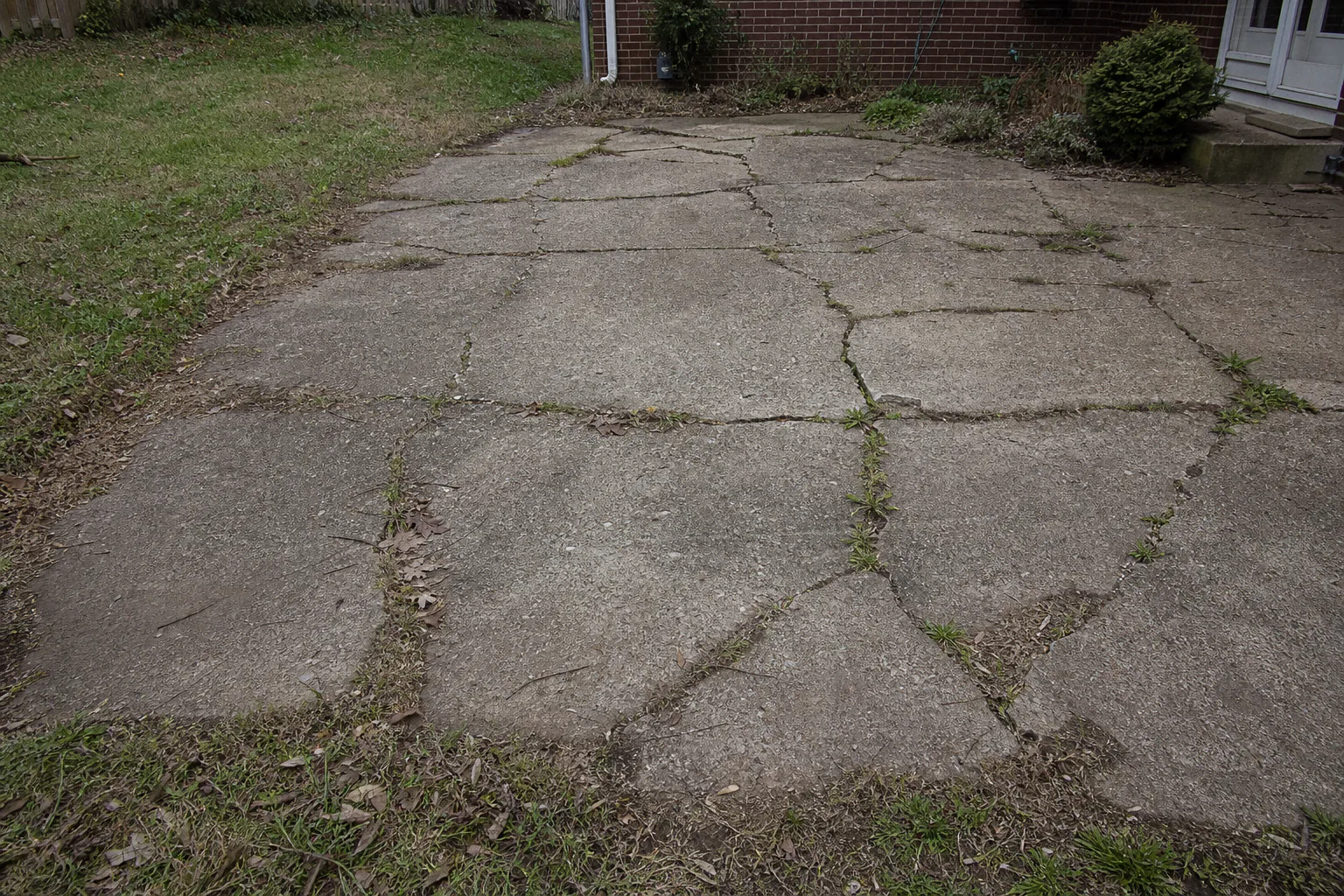 Cracked concrete patio in the Chevy Chase backyard before construction
