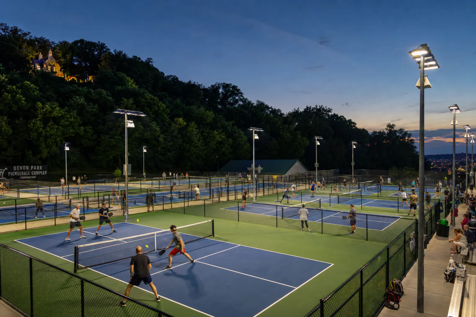 Completed Devou Park pickleball courts illuminated at dusk